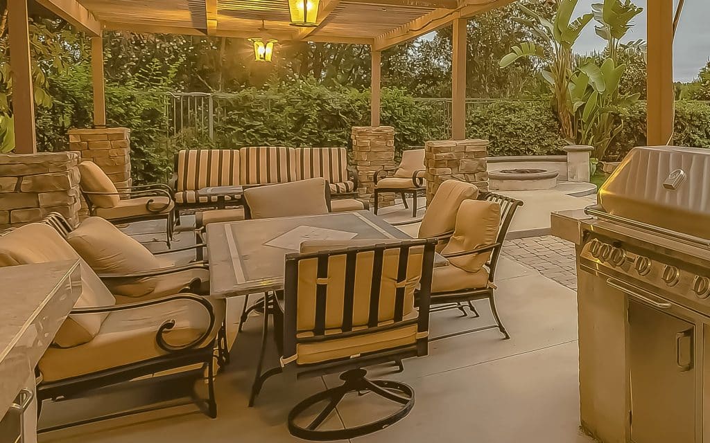 frame Outdoor kitchen and dining area under a pergola at the spacious patio of a home